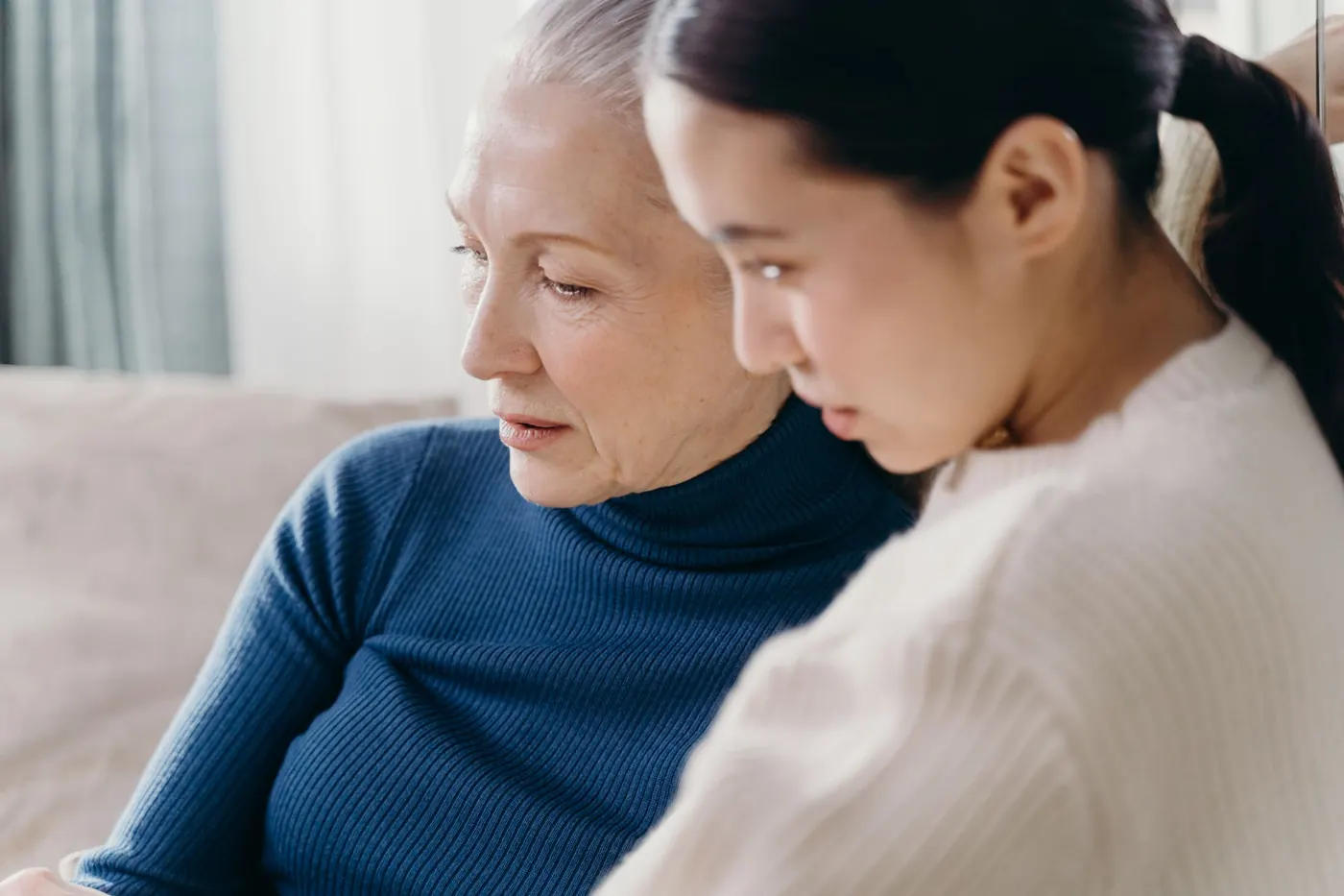 An older woman and a younger woman looking through paperwork together